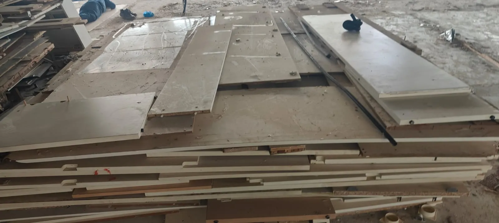 Flat-pack structural table panels stacked neatly on a construction site during a premium office shifting services Marathahalli move